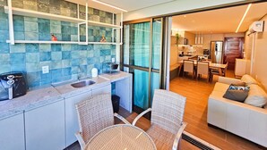 Una cocina moderna con un ventanal grande, una zona de comedor con sofá y vistas a la ciudad.