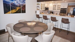 A modern kitchen with white cabinets, stainless steel appliances, and a central island with bar stools. - Magnificent, newly remodeled Snowmass Condo (Snowmass Village)