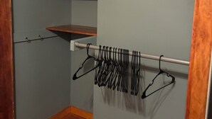 Un armario con estantes de madera y una barra para colgar ropa.