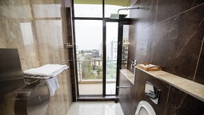 Une salle de bain moderne équipée de toilettes, d’un lavabo et d’un espace douche.