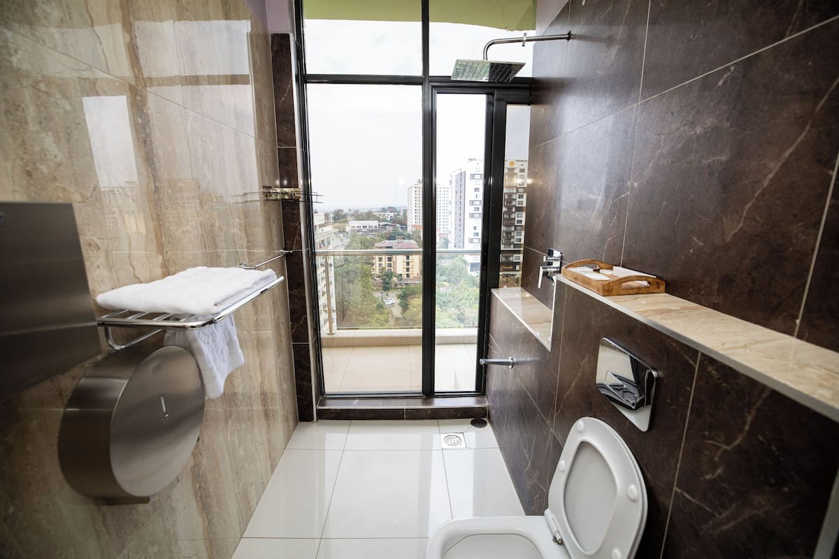 Une salle de bain moderne équipée de toilettes, d’un lavabo et d’un espace douche.