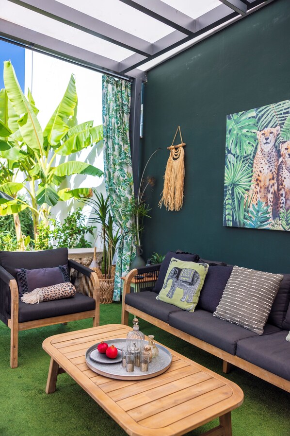 A cozy indoor seating area with a wooden table, two sofas, and a large plant. - Villa in Kournas with private pool and stunning sea views (Kournas)
