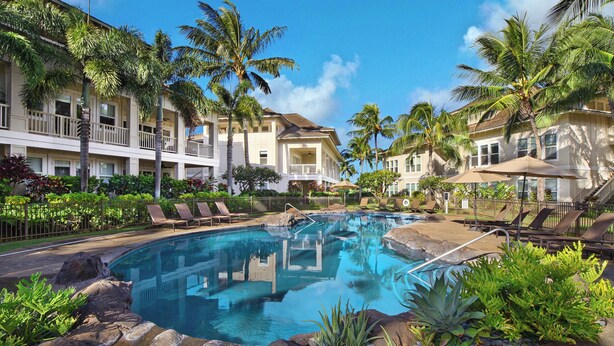 A hotel with a pool surrounded by palm trees and lounge chairs. - Penthouse with Panoramic Ocean Views From Private Lanais (Koloa)