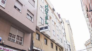 Un bâtiment d’hôtel avec une enseigne indiquant « HÔTEL » et « Hotel Alde Ribeira ».