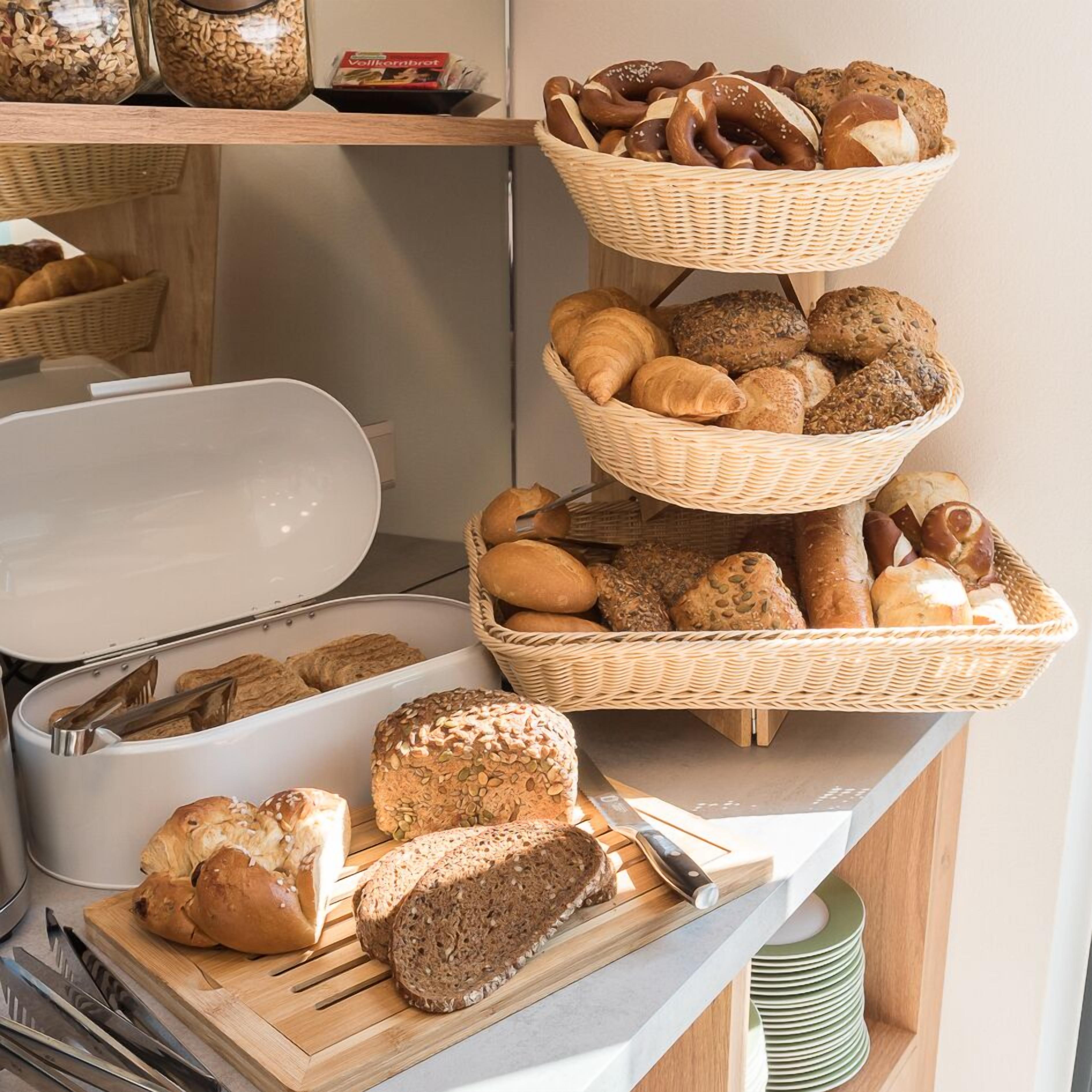 Diverse broden en gebak, waaronder croissants, baguettes en sneetjes brood, gepresenteerd op een toonbank.