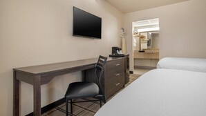 Ein Hotelzimmer mit einem Bett, einem Schreibtisch, einem Sessel, einem Fernseher, einer Kommode und einem Spiegel.