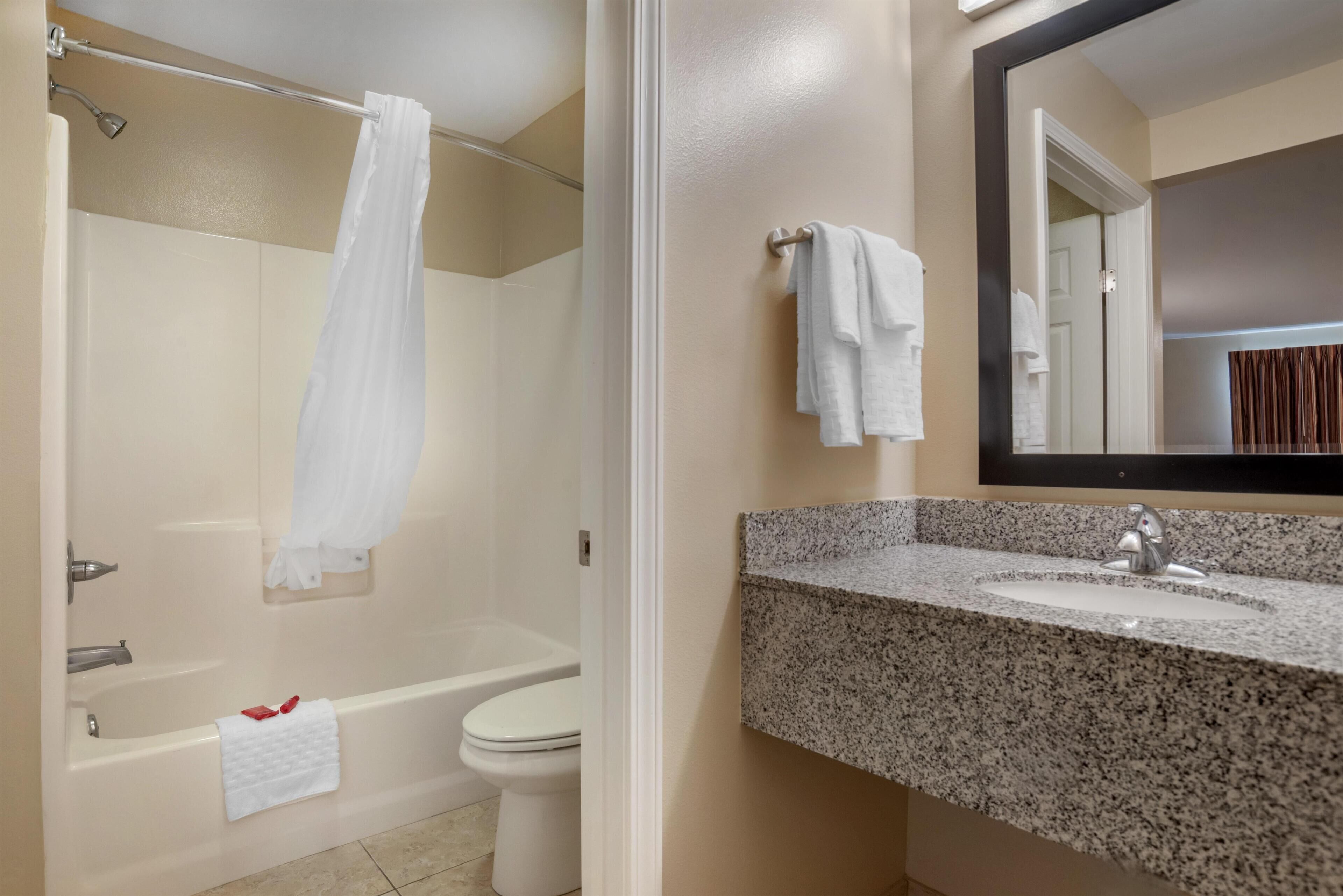 A bathroom with a bathtub, toilet, and sink.