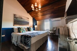 A bedroom with a bed, a painting, a chair, and a glass table. - Pousada do Joab - Fernando de Noronha (Fernando de Noronha)
