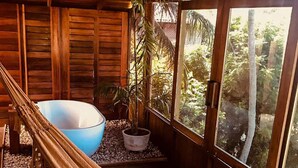 Una hamaca en una habitación de madera con vistas a la vegetación.