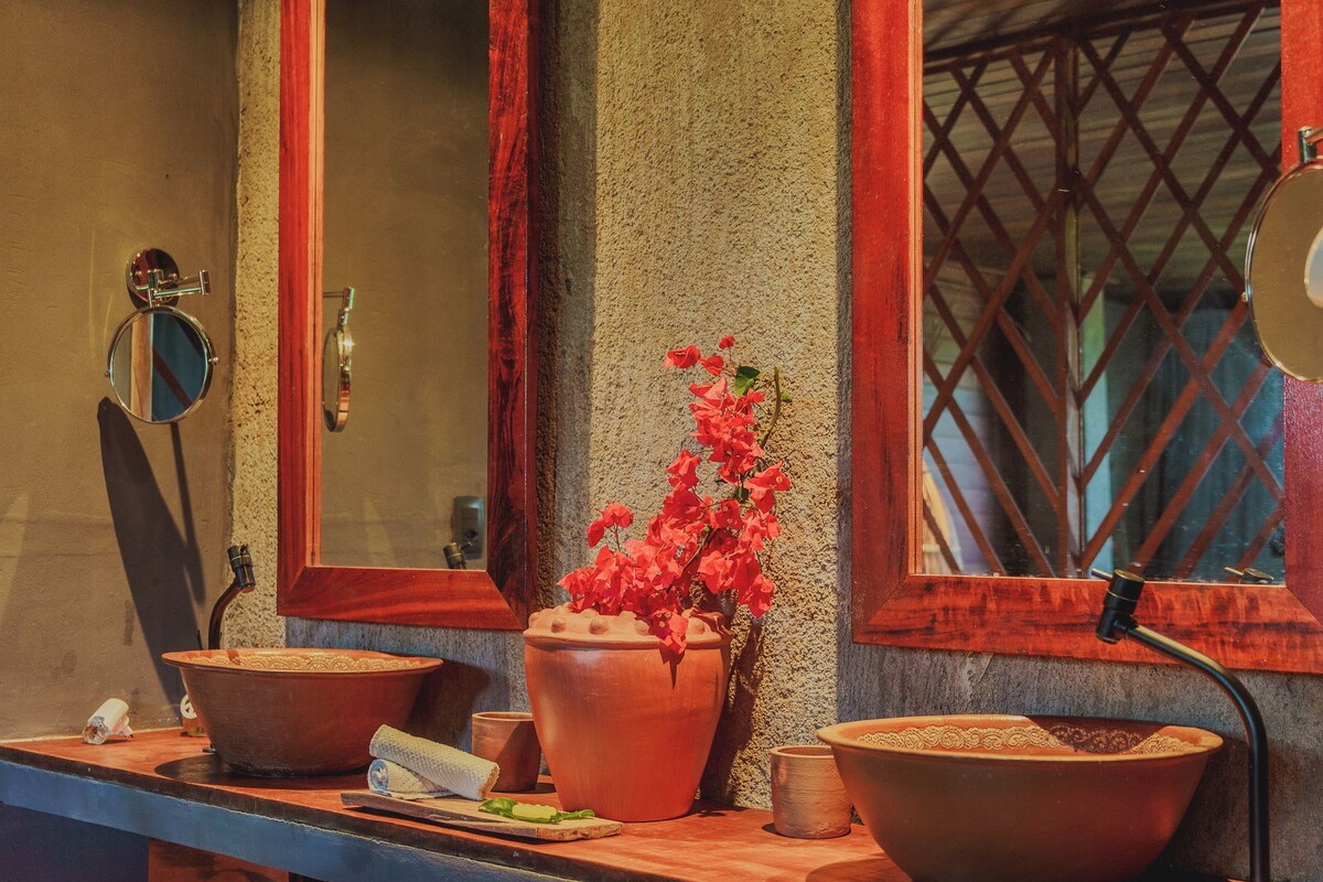 A bathroom with two sinks, a mirror, and a potted plant.