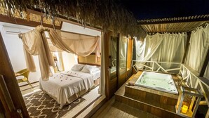 A bedroom with a canopy bed, a sitting area with a view, and a hot tub. - Aloha Village Hotel (Amontada)
