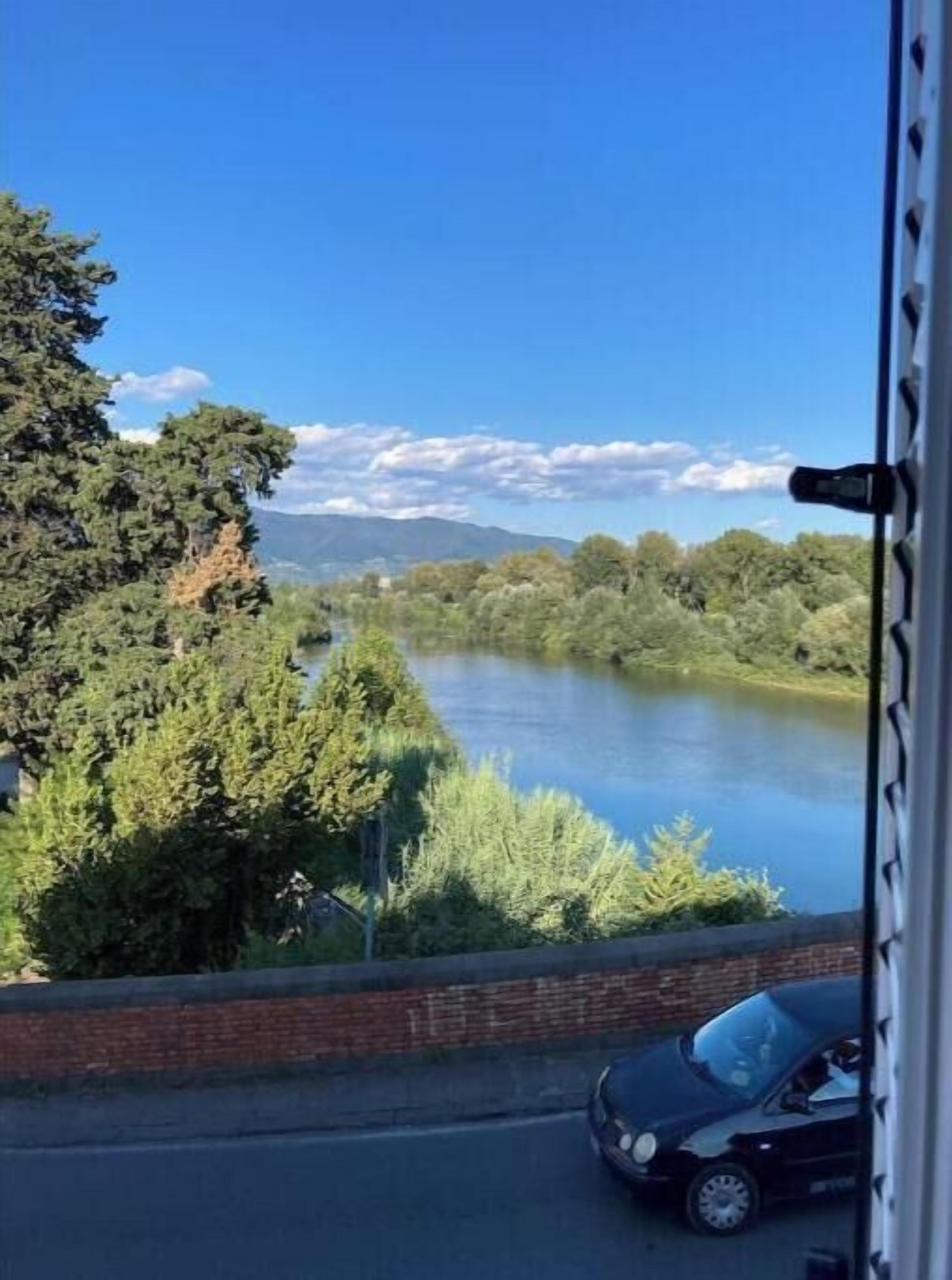 Un río con árboles y montañas al fondo.