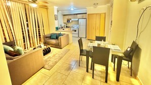 A compact living space with a sofa, a dining table, and a kitchen area in the background. - Beautiful private apartment Ecovivienda Etapa 1 (8 minutes American Embassy) (Tegucigalpa)