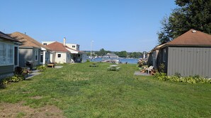 Zona verde con mesas de picnic y un muelle que se adentra en el agua.