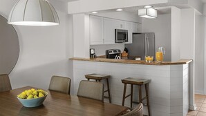 A modern kitchen with white cabinets, a central island with stools, a microwave, and a refrigerator. - Marriott's Harbour Point - Hilton Head Island
2 Bedroom Villa (Hilton Head Island)