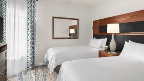 A hotel room with two beds, a wooden headboard, a nightstand with a lamp, a mirror, and a patterned curtain. - Marriott's Harbour Point - Hilton Head Island
2 Bedroom Villa (Hilton Head Island)