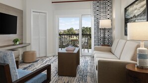 A modern living room with a sofa, a coffee table, and a TV mounted on the wall. There is a balcony with a table and chairs, and a patterned wall. - Marriott's Harbour Point - Hilton Head Island
2 Bedroom Villa (Hilton Head Island)