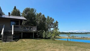 Ett hus med en veranda och utsikt över en sjö.