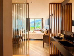 Een moderne hotelkamer met balkon, een bed, bureau en een badkamer.