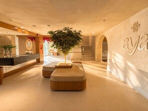 Eine moderne Lobby mit Empfangsbereich, Sitzgelegenheiten und einer Treppe.