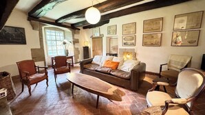 Una sala acogedora con un sofá de cuero marrón, sillas de madera, una mesa de centro de madera y una chimenea.