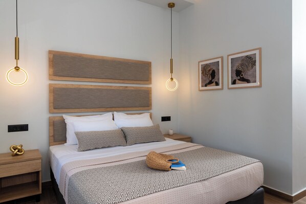 A modern bedroom with a large bed, two bedside tables, a headboard, and two pendant lights. - Bali Seaside Sailor (Mylopotamos)