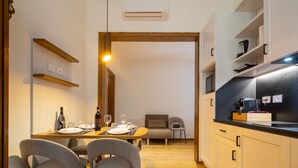 A compact kitchen with a dining area, wooden cabinets, and a built-in microwave. - Cetra Suite a stone's throw from Santa Maria Novella (Firenze)
