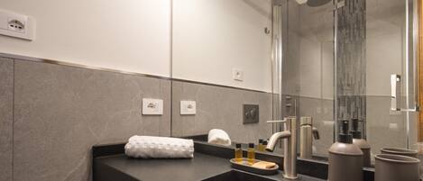 A modern bathroom with a black sink, a mirror, and a shower area.