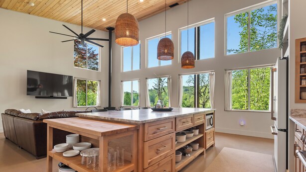 Una cocina amplia con una isla grande, muebles de madera y un ventilador de techo.