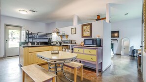 A compact kitchen with a dining area, a ceiling fan, and a microwave. - Villa 101 · Peaceful River Views · Steps to Water (Glen Rose)