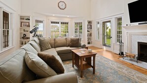A spacious living room with a sectional sofa, a wooden coffee table, and a fireplace.