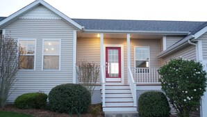 A single-story house with a red door, white railings, and a small porch. - The Harbor Hideout - Riverside home near Beaches, Pier, downtown shops (St. Joseph)