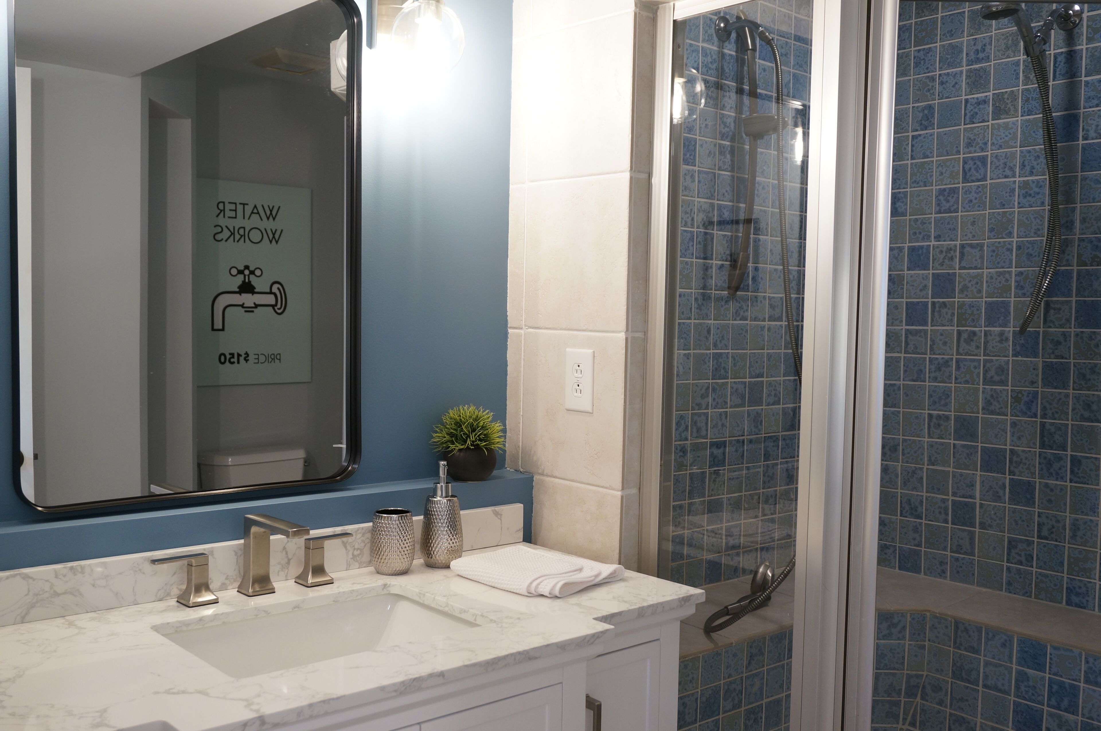 Une salle de bain avec un miroir, un lavabo et une douche.