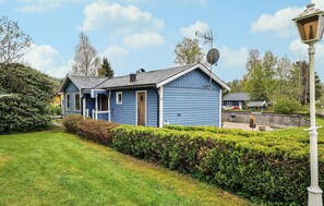 A blue house with a satellite dish, a chimney, and a small porch. - 2 bedroom beautiful home in Västerlanda (Västerlanda)