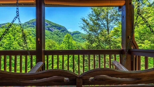 Eine Holzterrasse mit Blick auf eine gebirgige Landschaft.