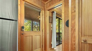 Ein Innenbereich mit Holzboden und einer verschiebbaren Glasdoor, die zu einem Balkon führt.