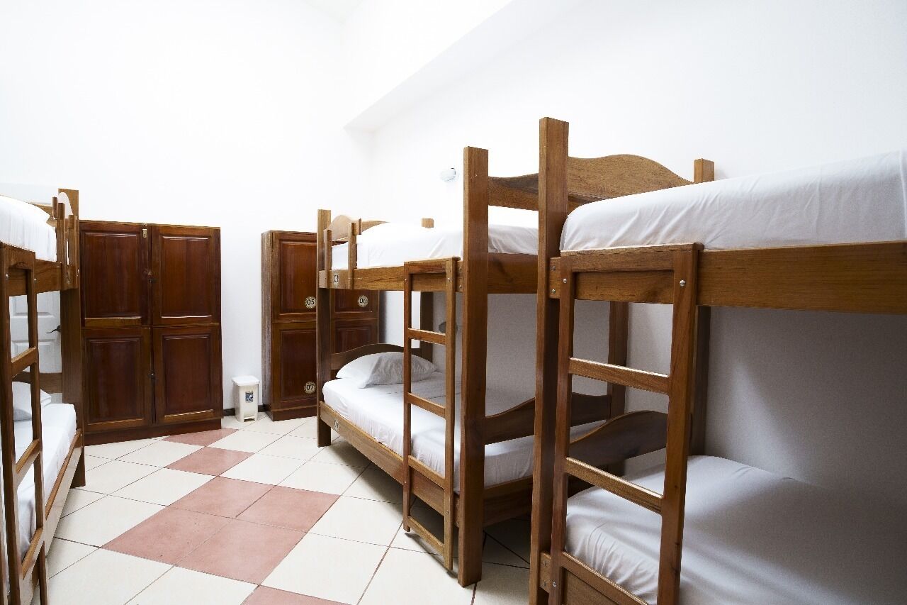 Un dormitorio con literas, armarios de madera y suelo de baldosas.