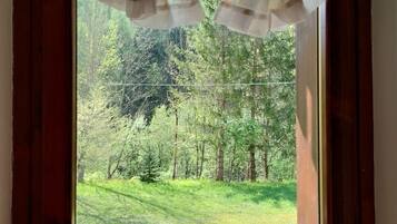 Step out onto a serene balcony with a lush green view.