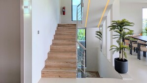 Un intérieur moderne avec un escalier, un extincteur et une plante en pot.