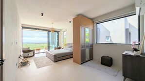 Une chambre spacieuse avec un grand lit, une armoire et une vue sur l’extérieur.