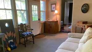 A cozy living room with a sofa, a wooden cabinet, and a chair with a blue cushion.