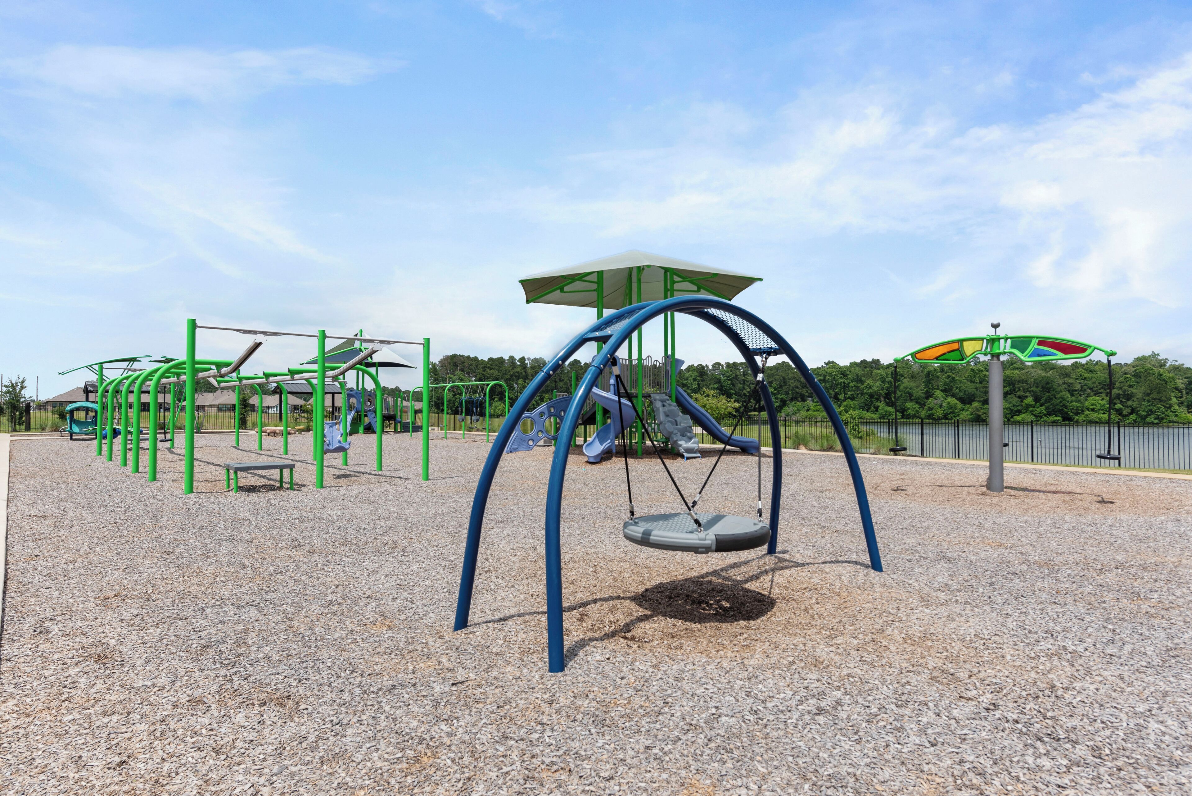 A playground with swings, climbing structures, and a covered seating area.