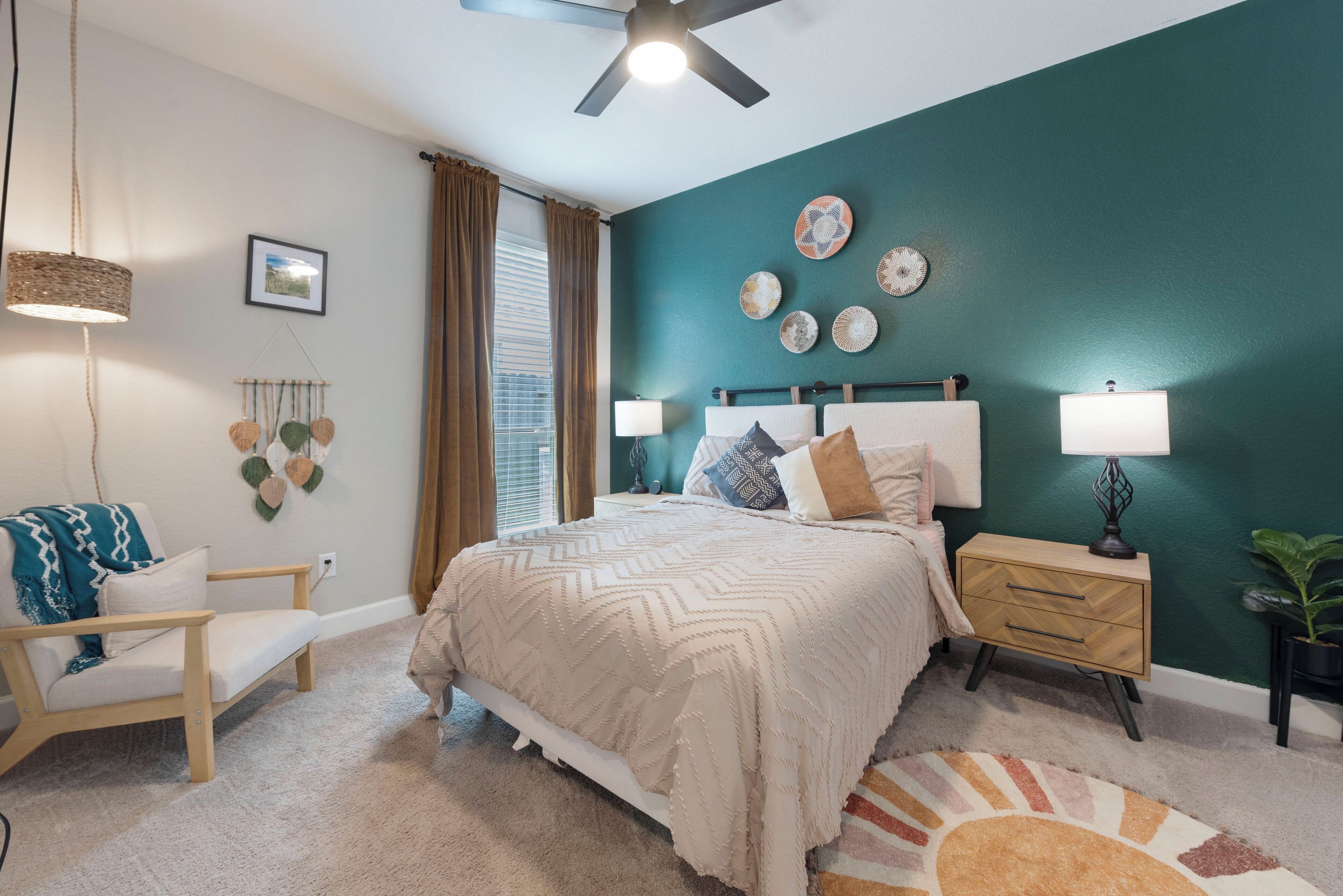 A bedroom with a bed, bedside tables, a chair, and a ceiling fan.