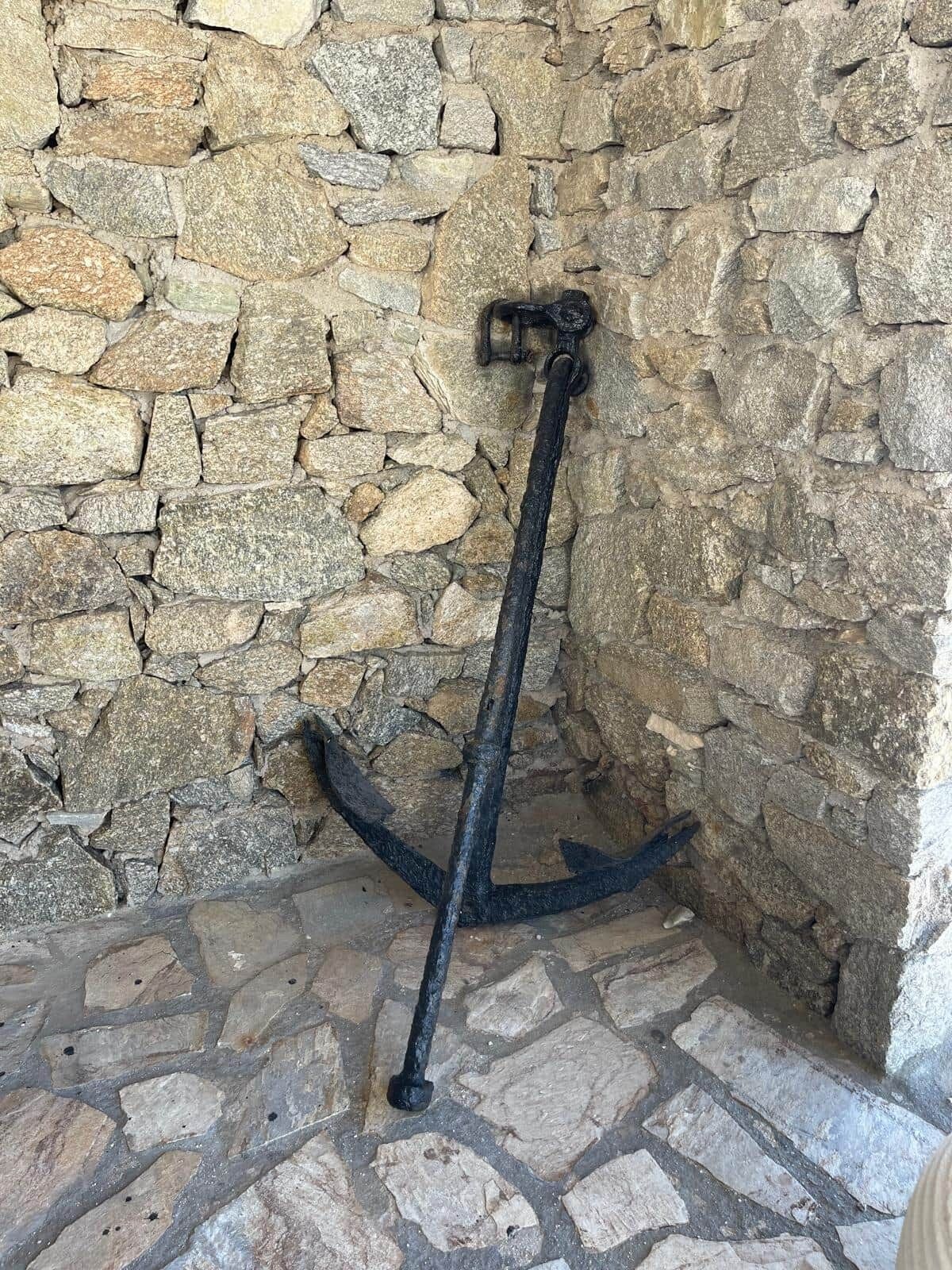A stone wall with a metal anchor embedded in it.
