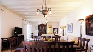 A dining area with a wooden table, chairs, and a chandelier.