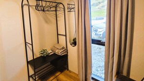 A room with a bunk bed, a small table with a plant, a window with curtains, and a view of a car outside. - Cosy Northern Ligths Cabin with hot tub and magical views on the Golden Circle (Grímsnes- og Grafningshreppur)