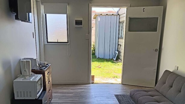 Un dormitorio con cama, sofá, escritorio y ventana.