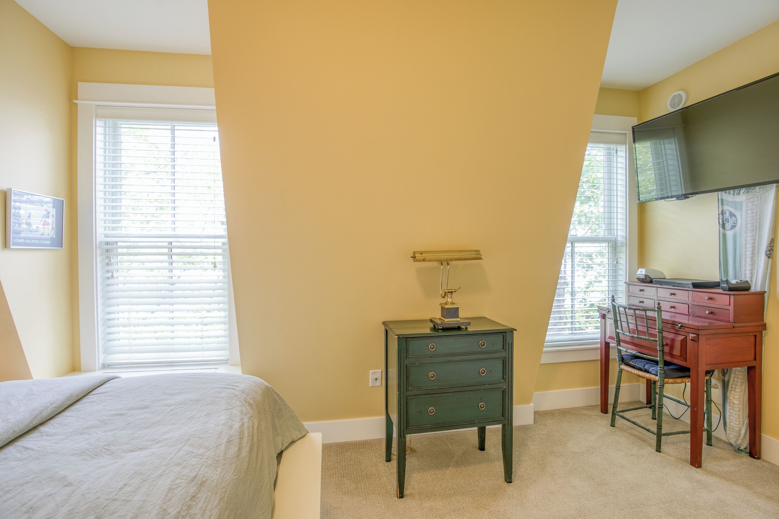 The master bedroom has a desk set up and smart TV. 
