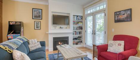 A living room with a fireplace, a bookshelf, and a red armchair.