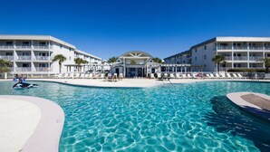 Ein Hotel mit Schwimmbad, mehreren Balkonen und einem überdachten Bereich.